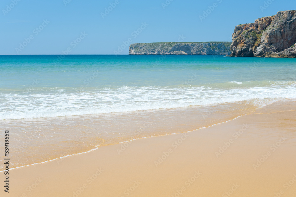 Sunny sandy beach with slightly waves