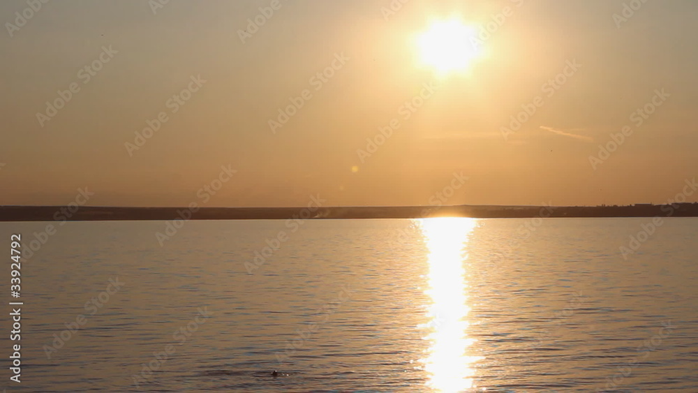 Young females swimming in the water over sunset Young females swimming in the water over sunset