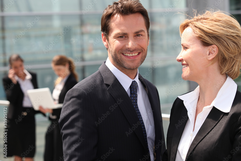 Businesswoman looking at businessman smiling Businesswoman looking at businessman smiling