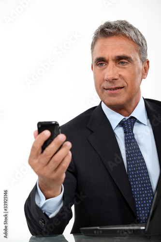 Director sending text message on phone