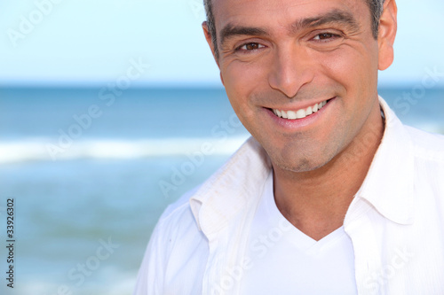 Closeup of a smiling man standing by the ocean