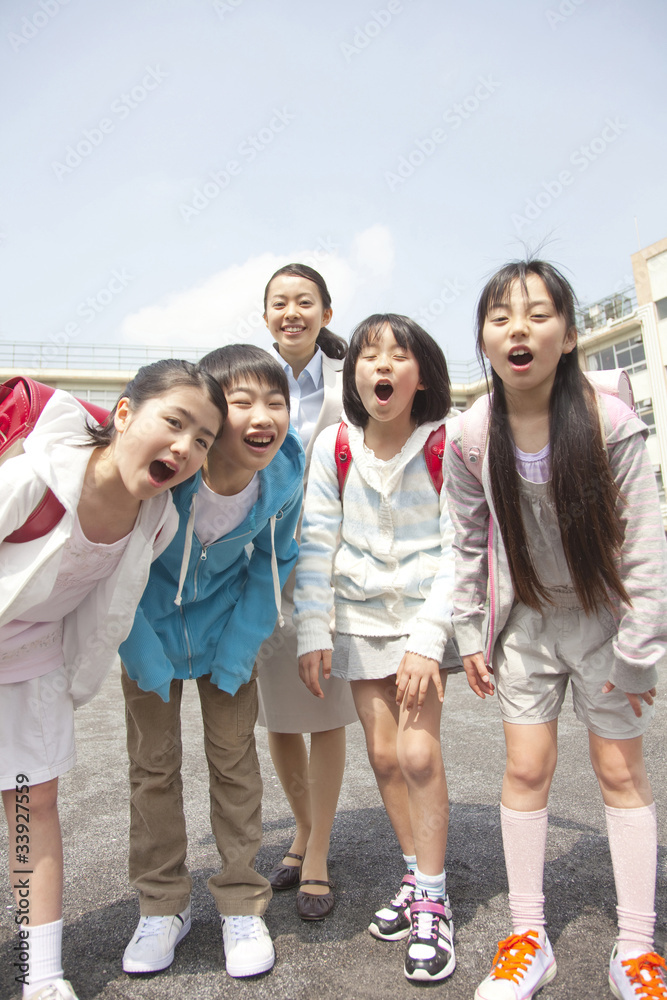 笑顔の小学生4人と女性教師