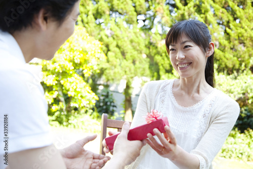 男性からプレゼントを受け取り喜ぶ女性