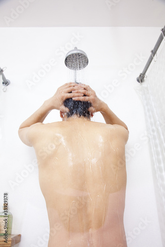 シャワーを浴びる男性の後ろ姿