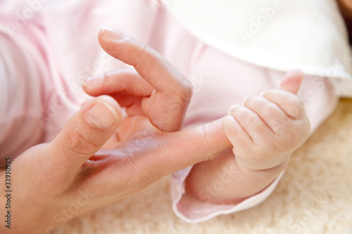 母親の小指を掴む赤ちゃんの手元
