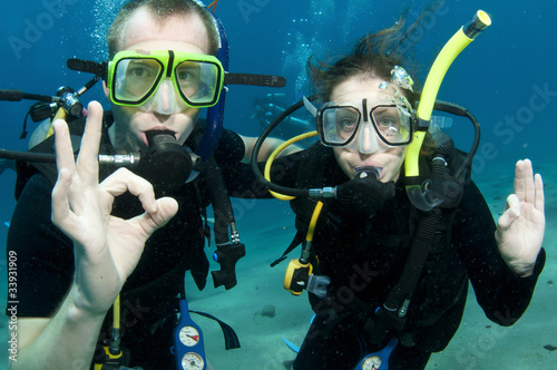 Scuba divers, man and woman give OK sign underwater © JonMilnes