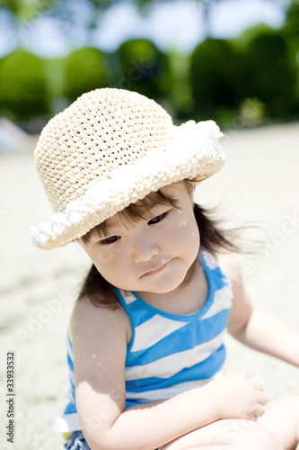 公園で遊ぶ麦藁帽子の女の子