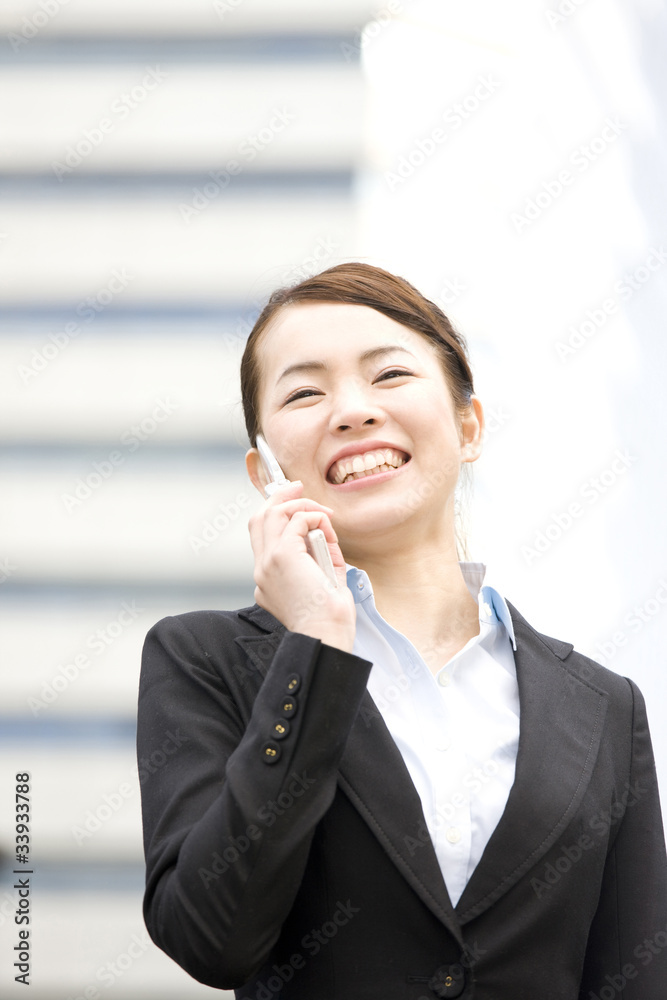 携帯電話で通話するOL