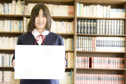 図書室でメッセージボードを持っている女子中学生