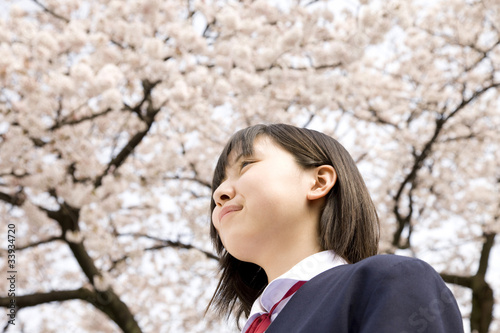 桜の下で笑っている女子中学生