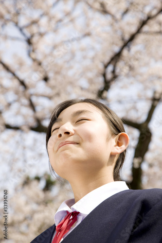 桜の下で微笑んでいる女子中学生