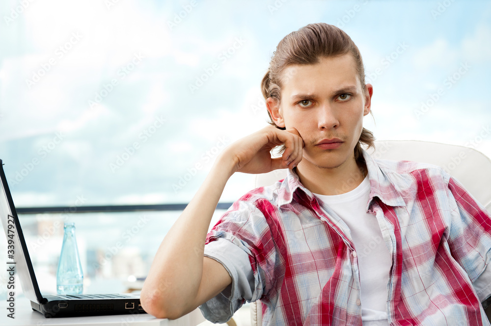 Portrait of handsome young man working with laptop on freelance