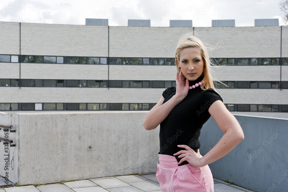 blonde girl posing in front of business building