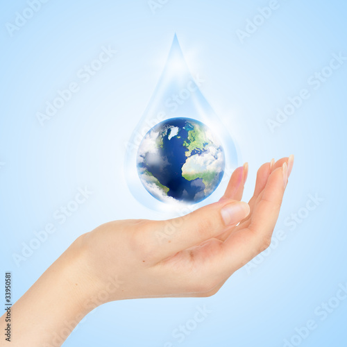 Drop of water with Earth inside and hand