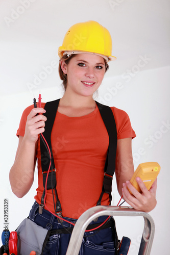 Female electrician using a voltmeter photo