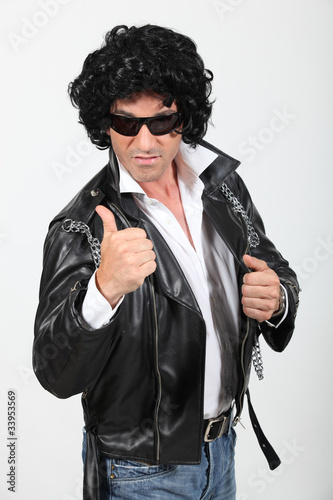 Ironic rocker in a wig and leather jacket