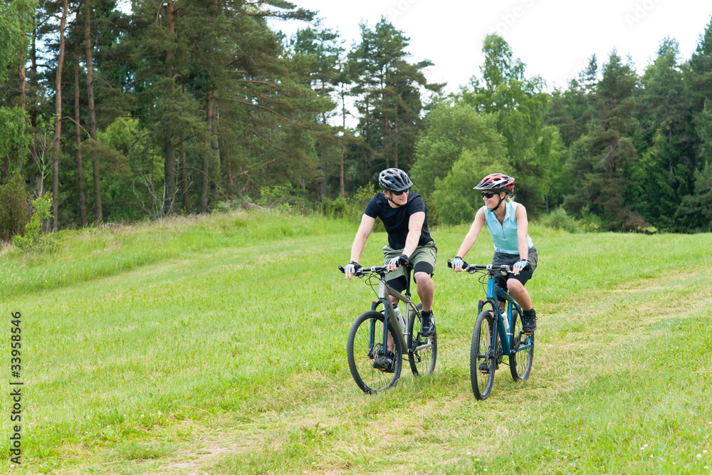 Sport happy couple riding bicycles in countryside Sport happy couple riding bicycles in countryside