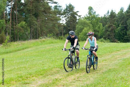 Sport happy couple riding bicycles in countryside