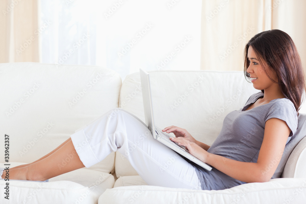 smiling woman on sofa with notebook smiling woman on sofa with notebook