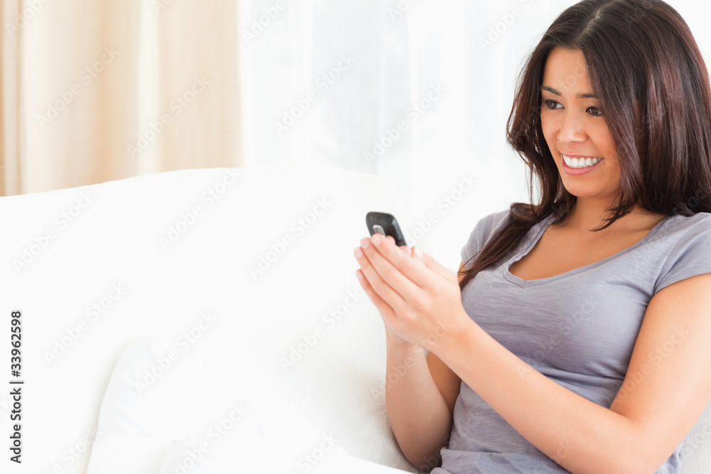 woman sitting on sofa looking at mobile phone woman sitting on sofa looking at mobile phone