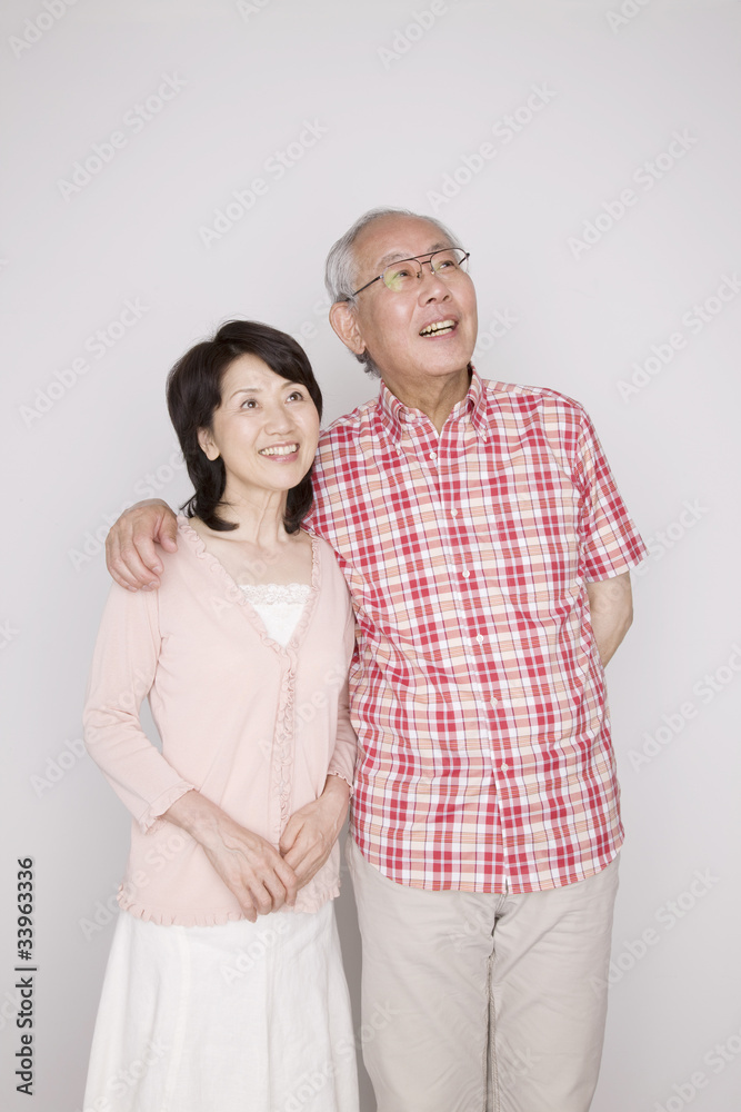 妻の肩に手をのせて寄り添っている夫 妻の肩に手をのせて寄り添っている夫