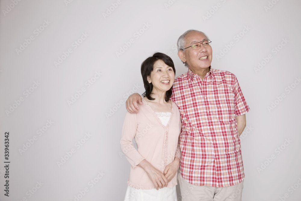 妻の肩に手をのせて寄り添っている夫