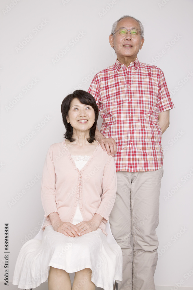 椅子に座る妻の後ろに立つ夫 椅子に座る妻の後ろに立つ夫