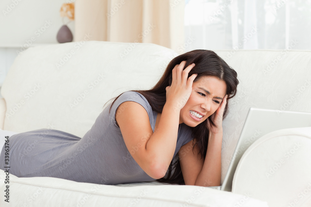angry woman lying on sofa with notebook angry woman lying on sofa with notebook