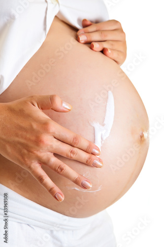Pregnant woman moisturising belly to avoid stretch marks