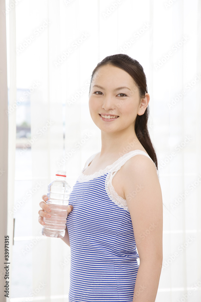 ペットボトルを持って笑っている女性