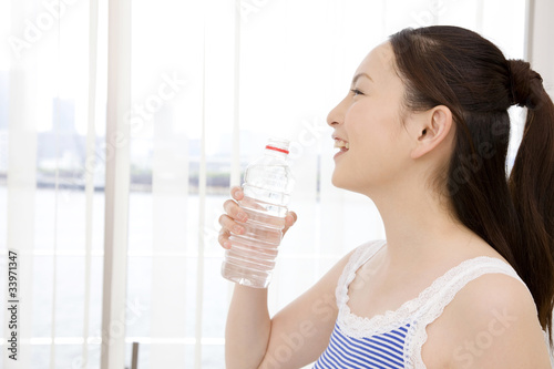 ペットボトルの水を飲んでいる女性