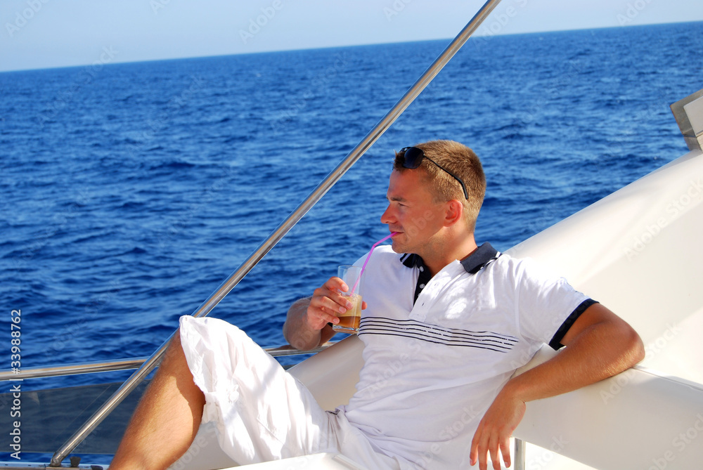 Sailor relaxing on boat drinking cold coffee