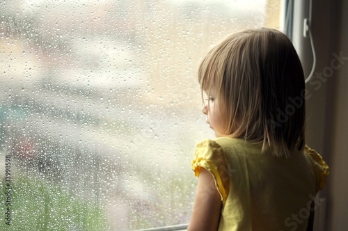 la jeune fille regarde par la fenêtre photo