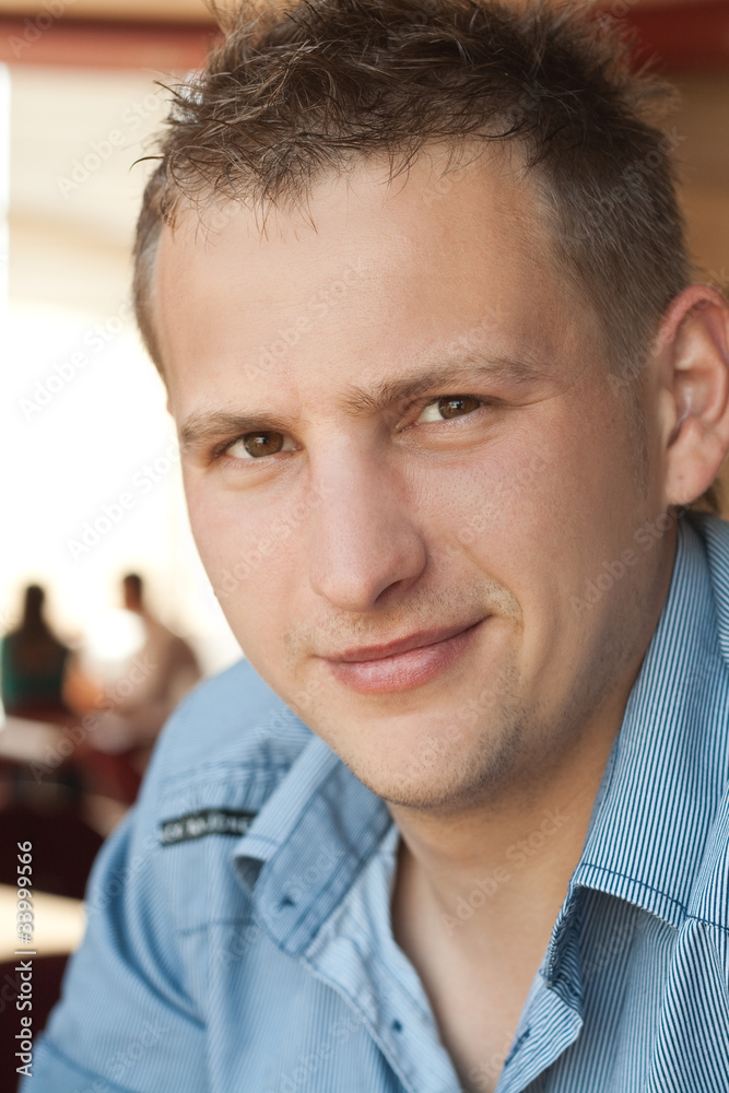Fototapeta premium Portrait of a young handsome guy in a cafe