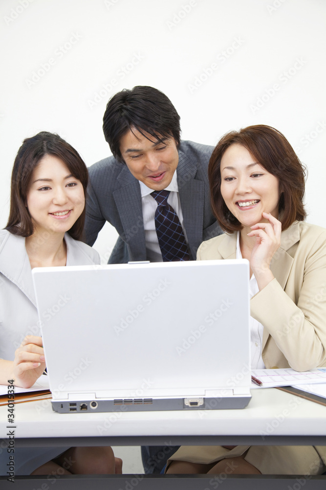 ノートパソコンを囲むビジネスマンとOL2人