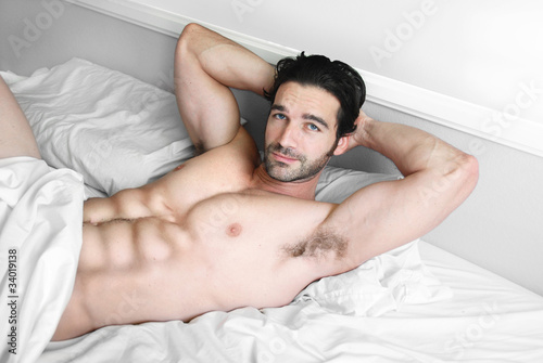 Sexy male model smile in bed