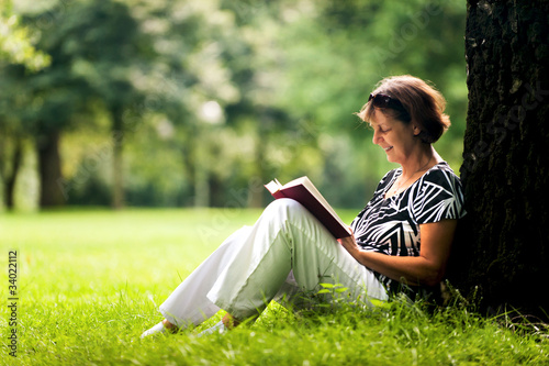 Frau liest Buch im Park photo