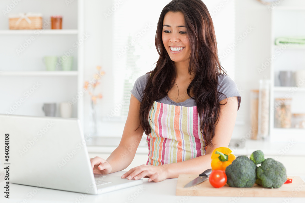 Gorgeous woman relaxing with her laptop while standing