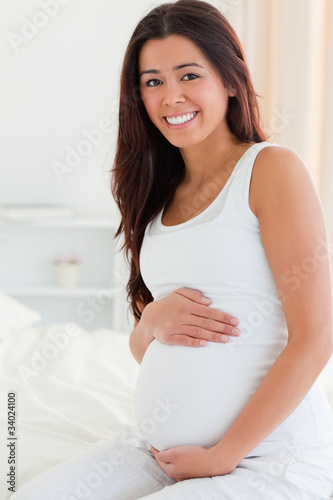 Portrait of a good looking pregnant woman touching her belly whi Free Download Portrait of a good looking pregnant woman touching her belly whi - GFXLoad