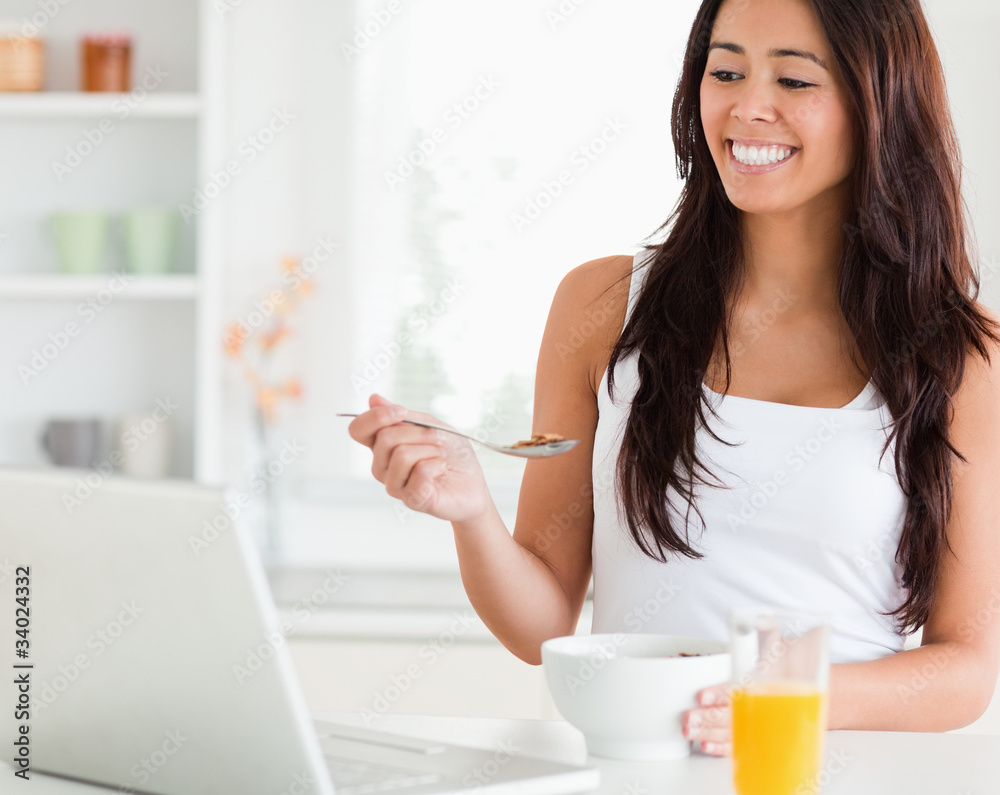 Beautiful woman enjoying a bowl of cereals while relaxing with h Beautiful woman enjoying a bowl of cereals while relaxing with h