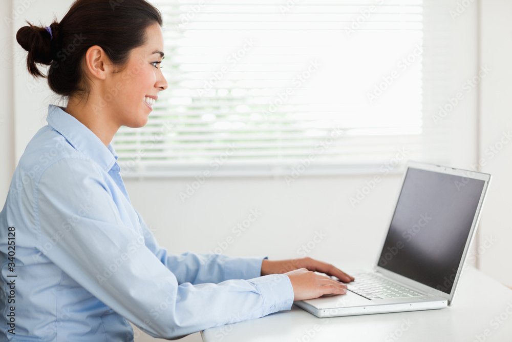 Attractive woman working with her laptop and typing while sittin Attractive woman working with her laptop and typing while sittin