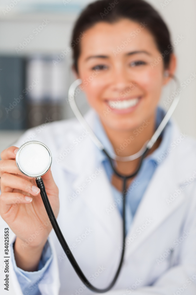 Lovely female doctor using a stethoscope while looking at the ca Lovely female doctor using a stethoscope while looking at the ca