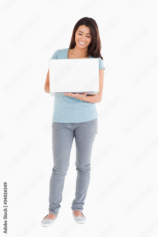Beautiful woman holding a laptop while posing Beautiful woman holding a laptop while posing