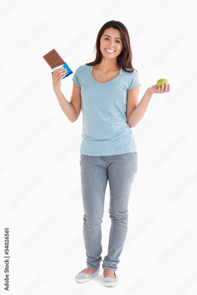 Pretty female holding a chocolate bar and an apple Pretty female holding a chocolate bar and an apple