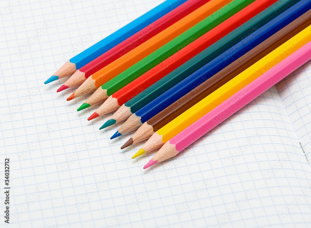 colored pencils on an open notebook colored pencils on an open notebook