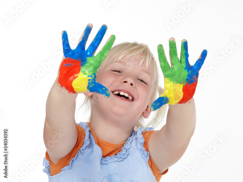Cute little girl with color painted hands has fun