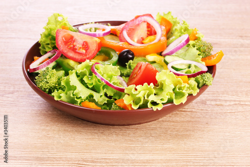 many vegetables on the plate on a wooden background
