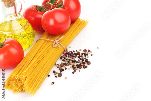 Pasta spaghetti with tomatoes, olive oil and basil on a white ba