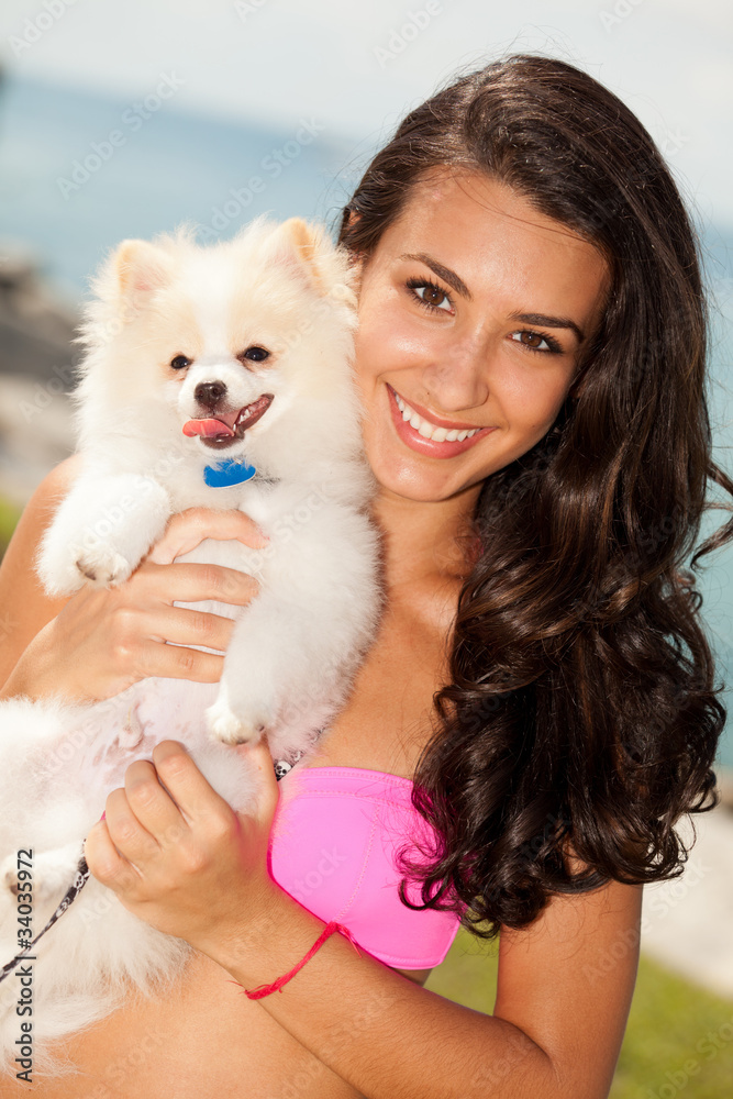 Pretty young brunette woman with her Pomeranian puppy Pretty young brunette woman with her Pomeranian puppy