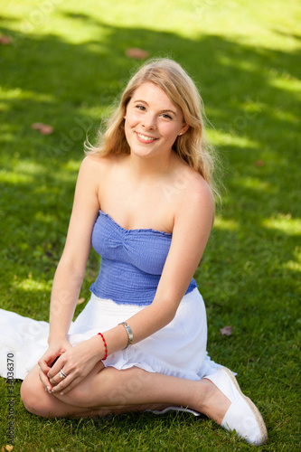 Pretty young blond woman in a park setting